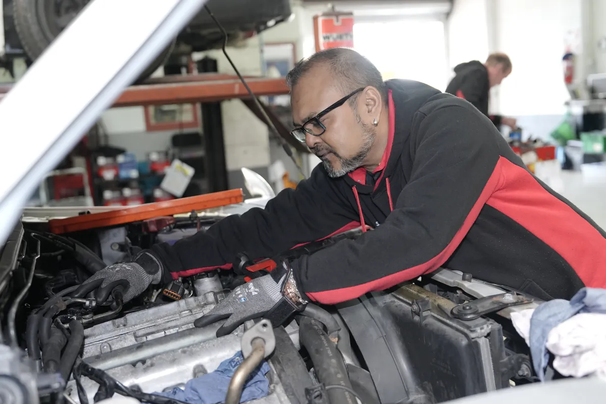 Car servicing underway in the HM Motors workshop, New Lynn